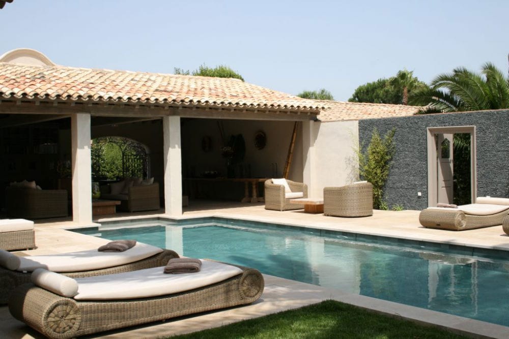 Aménagement d'un ensemble extérieur : terrasse et abord de piscine en pierre beige